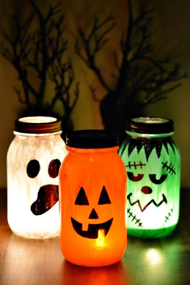 Spooky glass jar lanterns with eerie painted faces glowing in the dark.