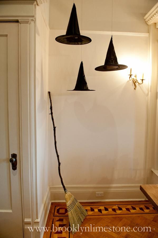 Black paper witch hats hanging from the ceiling in a whimsical display.